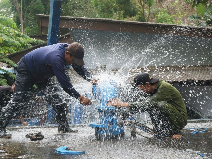 Men working to turn off leak